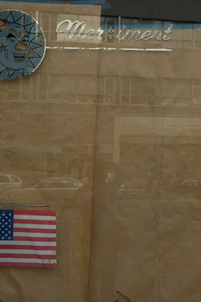 Old lettering on the window of a closed novelty store.