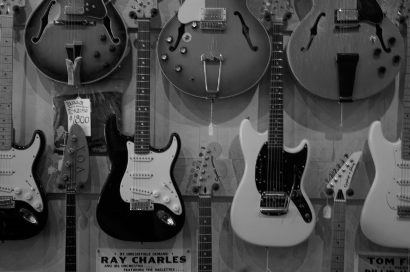 Used electric guitars on a wall of a store.