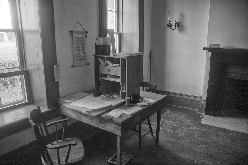 A chair, desk, and papers in an old room.