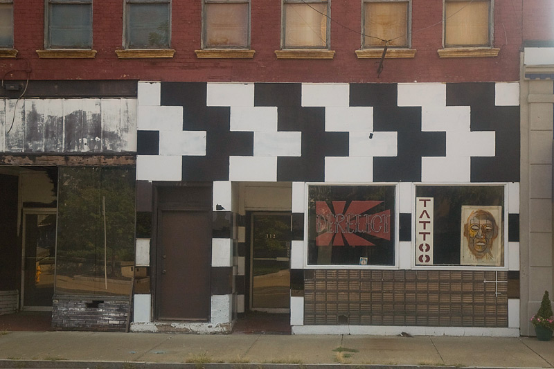 A tattoo parlor on an otherwise empty street.