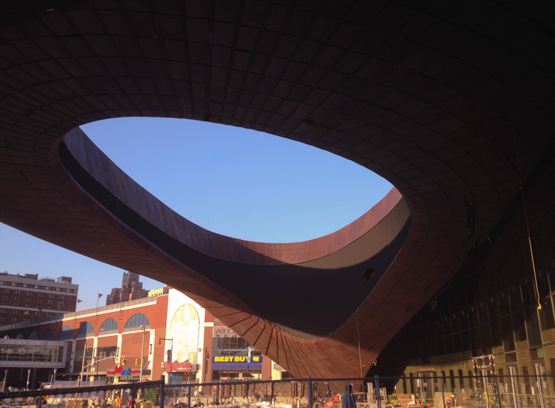 Curved metal entrance with opening to sky.