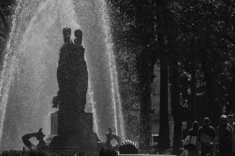 Two tall statues in a water fountain.