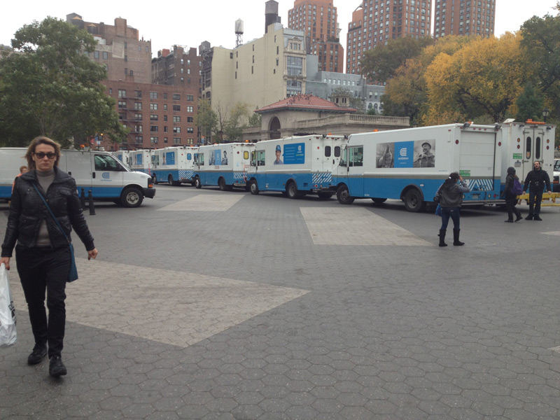 Many Con Edison trucks on a plaza.