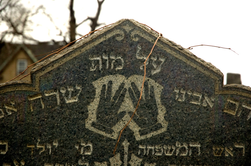 A tombstone, with two hands, fingers spread