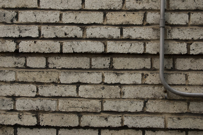 A brick wall, with an electrical conduit