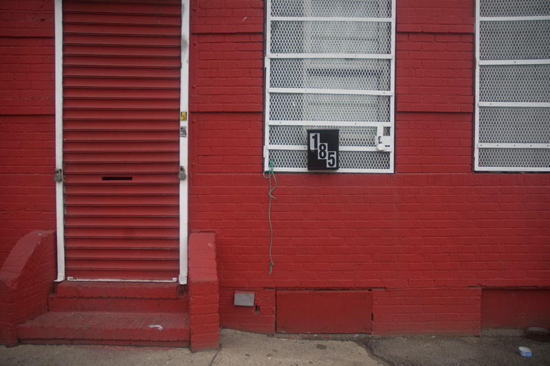 A brick building, brilliant red, with white trim.