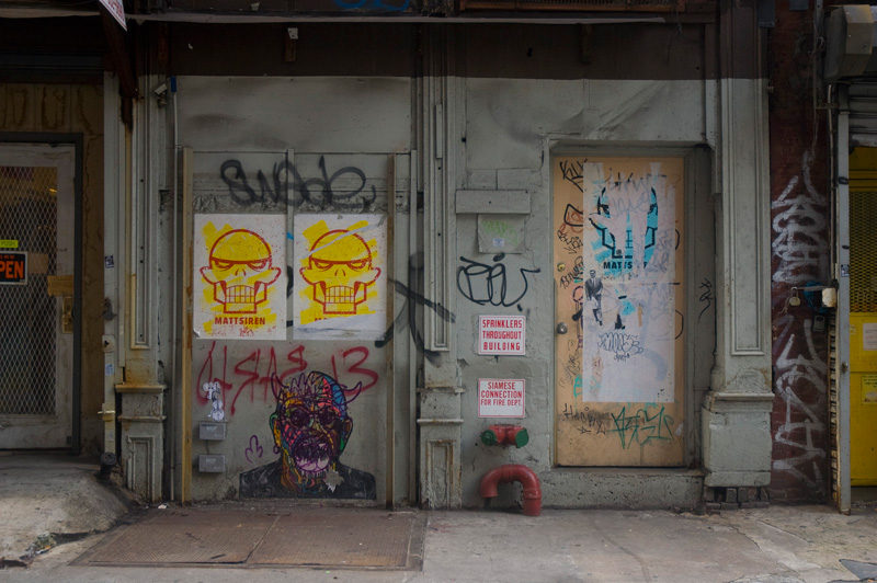 Graffiti and posters in an alley.