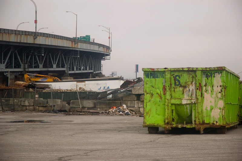 A green dumpster by the Brooklyn Queens Expressway.