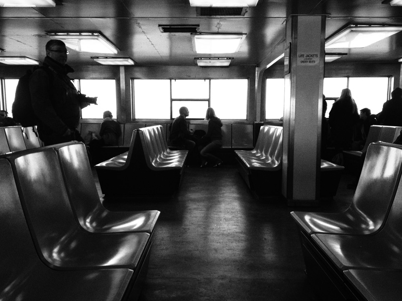 A couple gaze out the window on a ferry
