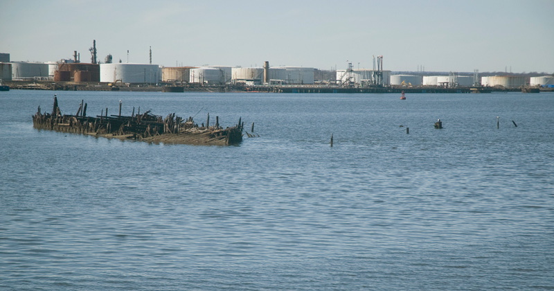 The shell of an abandoned boat, in water