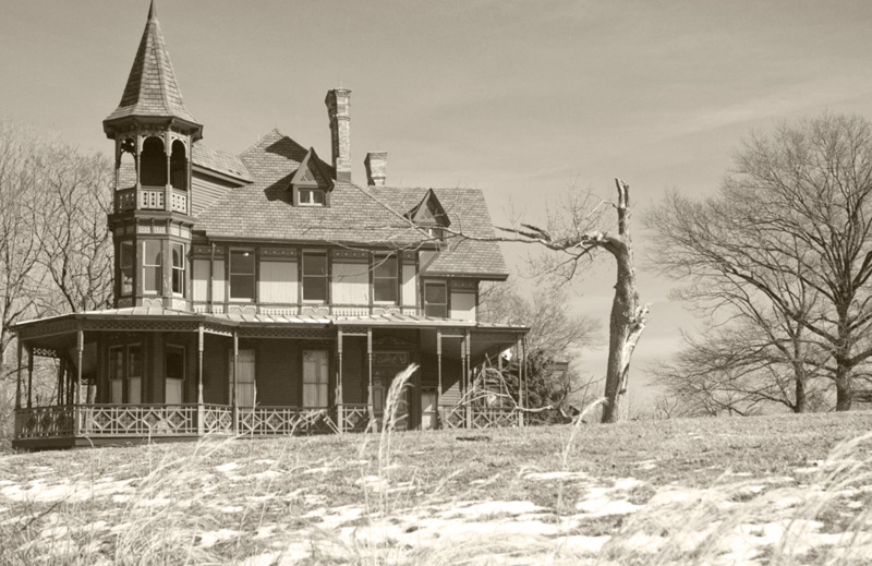 A mansion on a hill, with bare trees