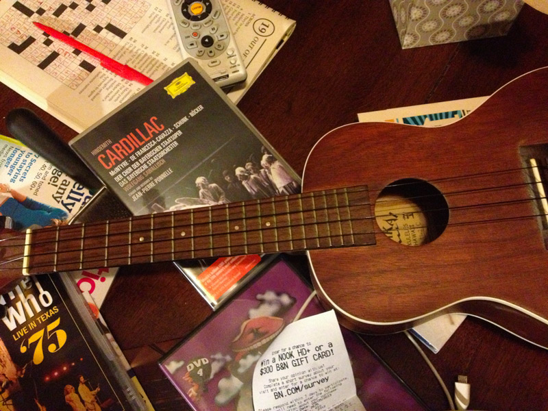 A ukulele and DVDs on a coffee table