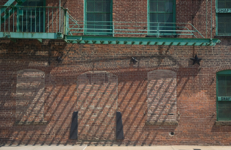 A fire escape's shadows on a brick wall