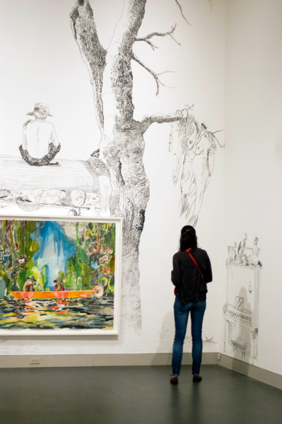 A woman viewing a painting on a painted wall