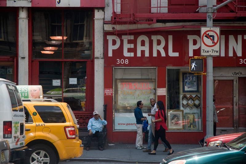 People walking past a red storefront