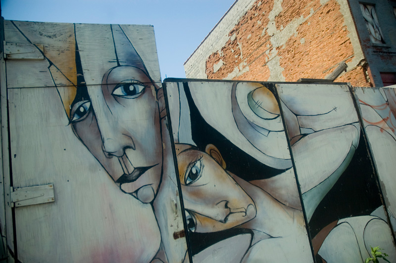 Stylized faces on a wooden fence