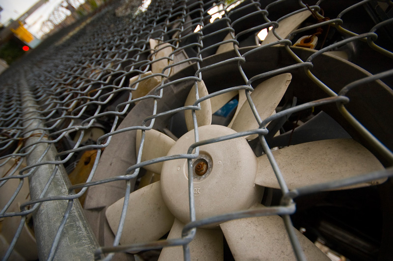 Old fan blades behind a fence.