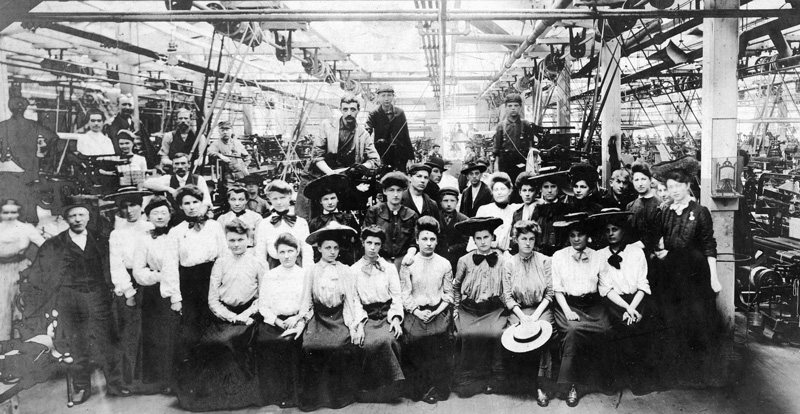 Factory workers in finery grouped for a photograph.