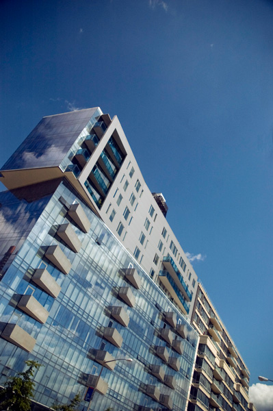 A glass-windowed building against a blue sky.