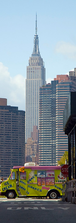 The Empire State Building towering over an ice cream truck.