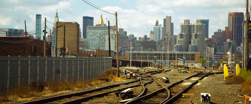 Railroad tracks, with Manhattan skyscrapers.