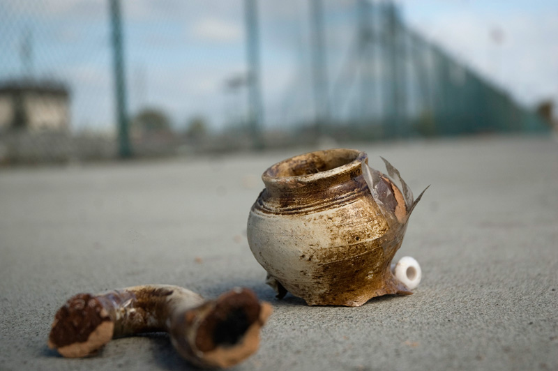 Broken pottery on a sidewalk.