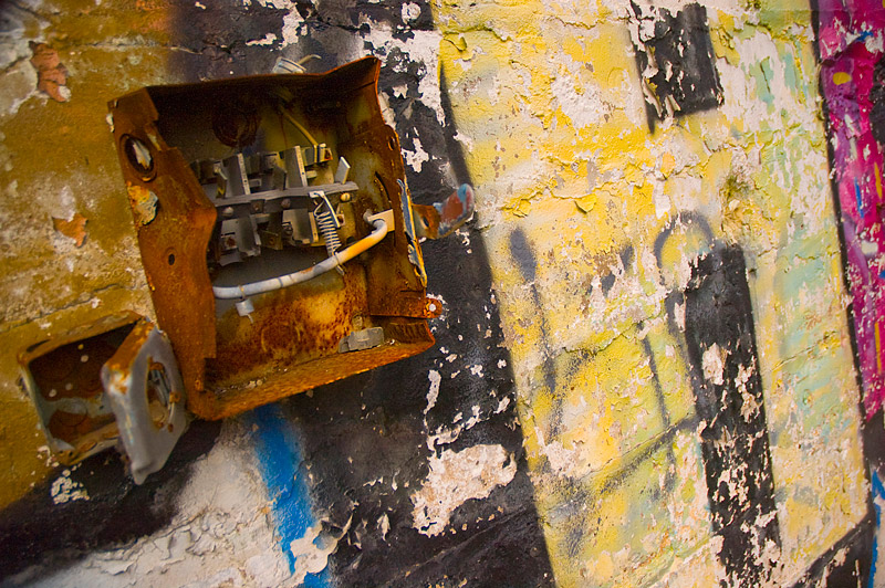 An electrical box on a graffiti covered wall.