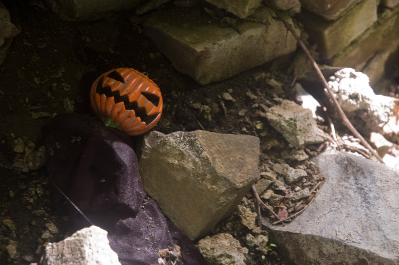 A plastic Jack o' Lantern among rubble.