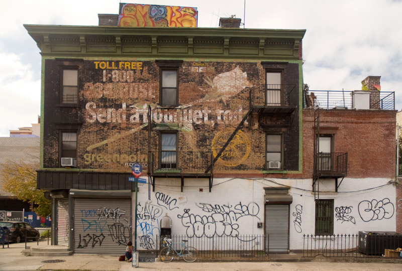 Faded sign for a florist on a building wall.