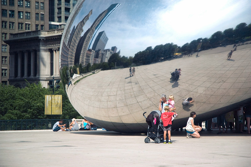 Tourists pausing before Clud Gate The Bean in Chicago.