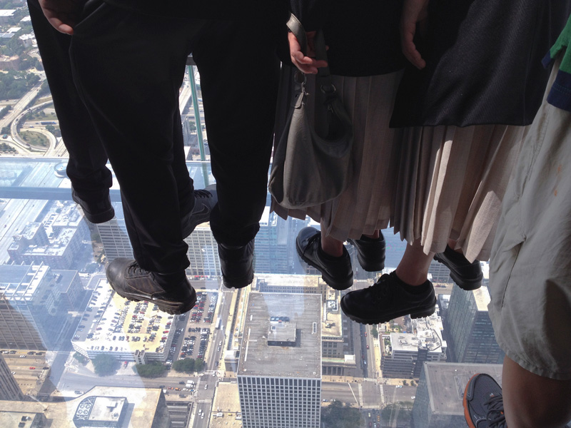 People viewing a city from a glass floor.