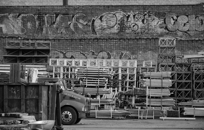 A yard with stacked pieces of scaffolding.