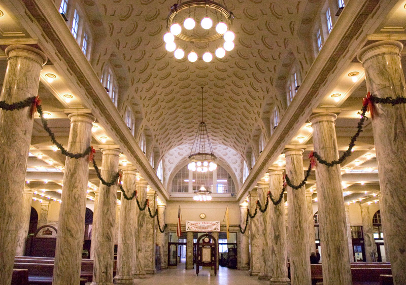 Aisle in a train station, with marble columns.