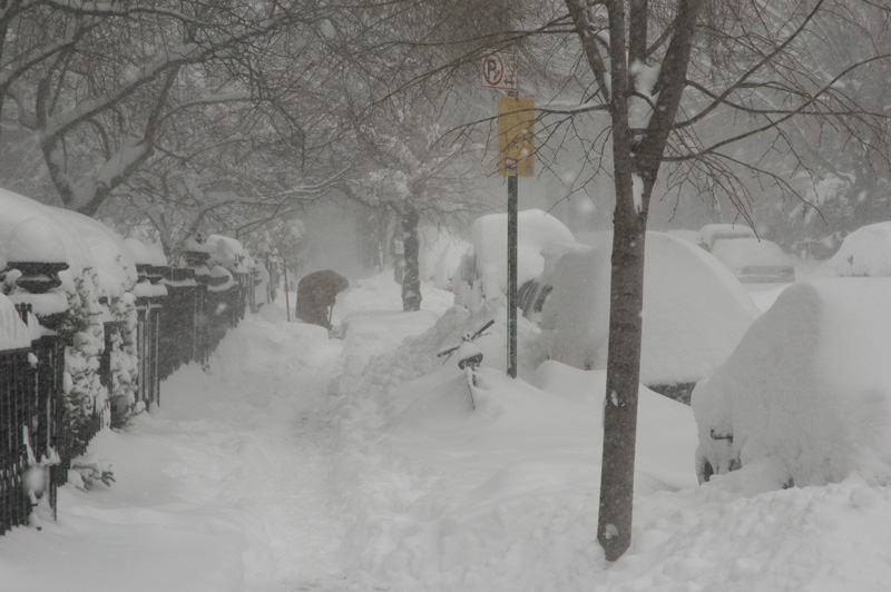 Shoveling snow on a sidewalk.