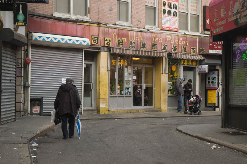 A man walks down a street with a bend.