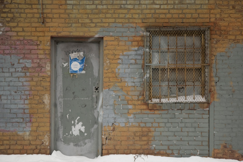 A metal door on an old brick building.