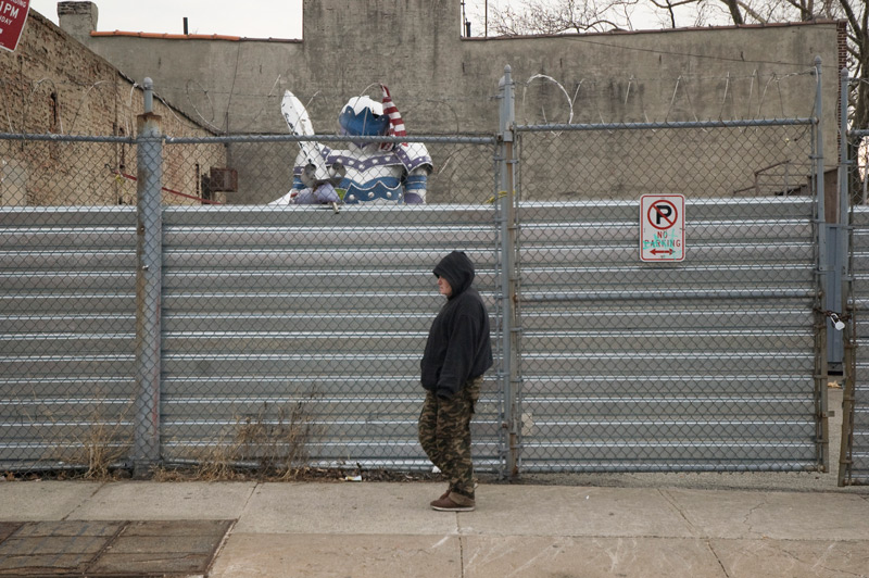 A large suit of armor peaking over a fence.