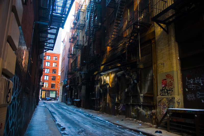 A tight alley, with fire escapes.