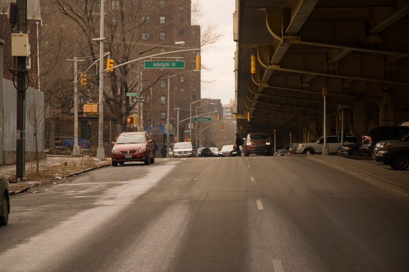 Cars on a road next to an expressway.