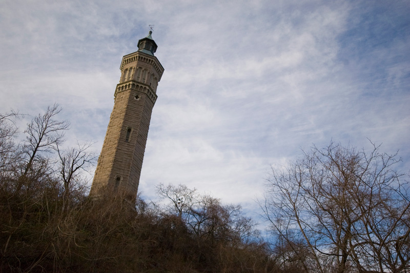 A brick tower, rising above winter trees.