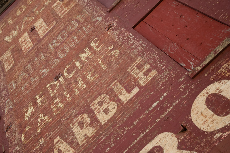 Old painted wall sign advertising tiles.