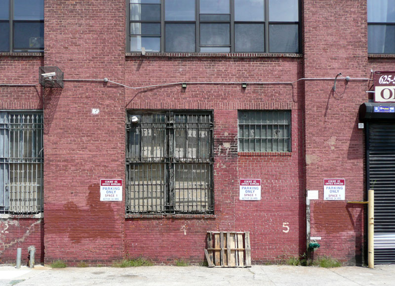 Brick industrial building, with barred windows.