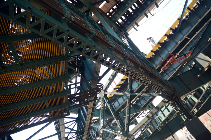 Elevated train tracks and a worker.