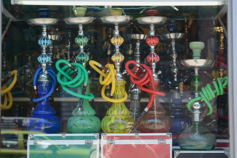 Colorful hookahs in a storefront window.