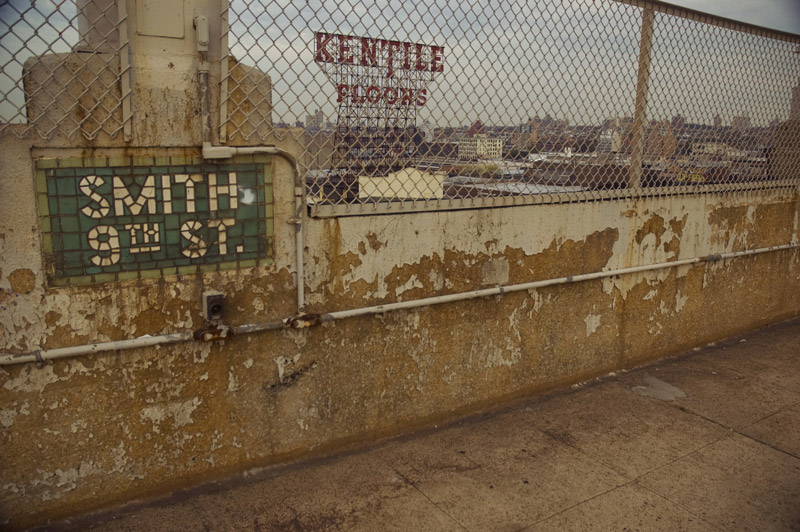 The Kentile Floors sign, behind a fence.