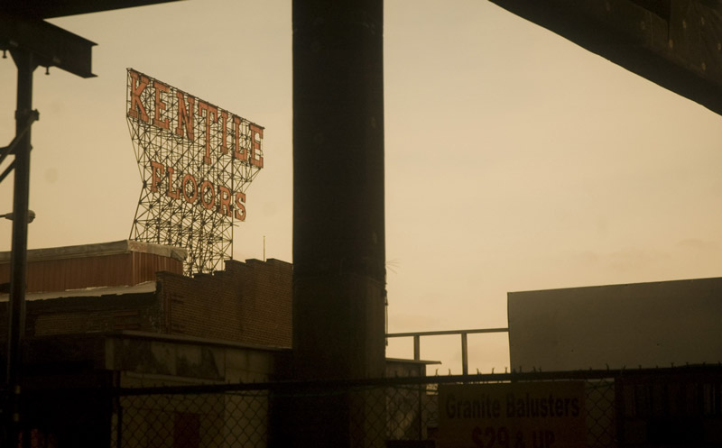 The Kentile Floors sign, framed by steel pillars and scaffolding.