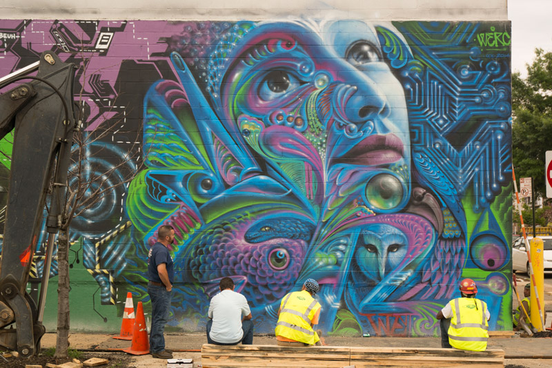 A colorful mural, with workers on break.