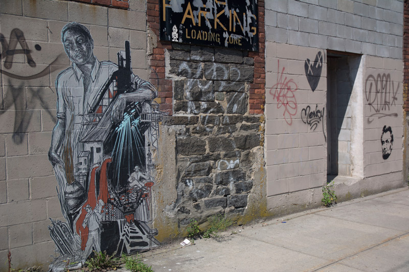 Wheatpaste street art, depicting factory work.