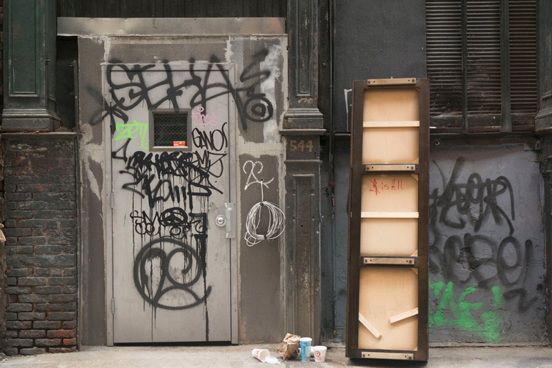 Paper cups outside an alley door.