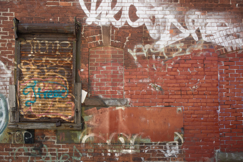 Brick building with graffiti and boarded-up windows